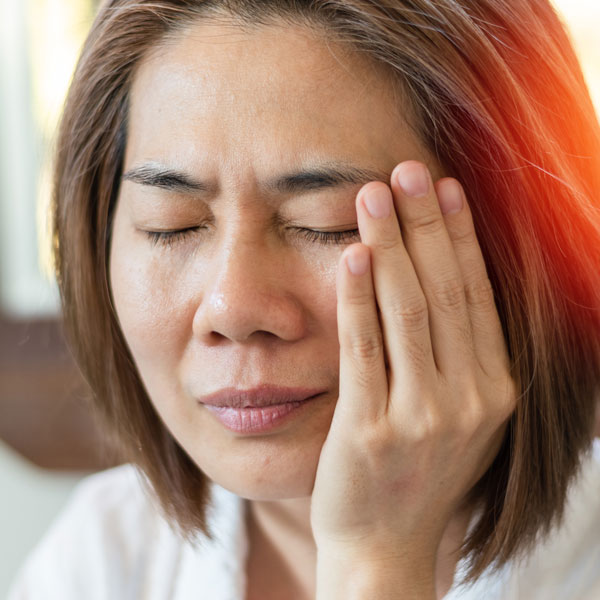 woman holding face in pain